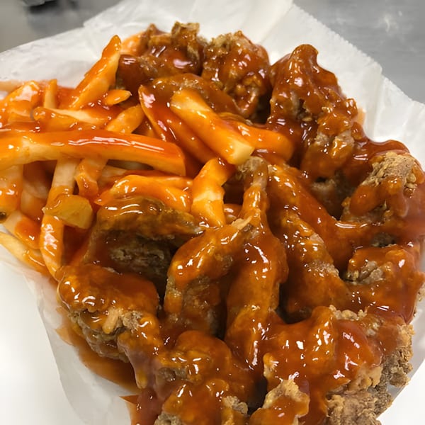 Harold's 25 fried chicken and fries, generously covered in a vibrant orange sauce.
