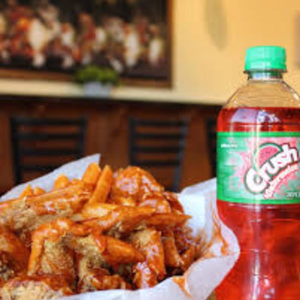 Harold's 25 fried chicken and fries covered in sauce, with a bottle of Crush Watermelon soda.
