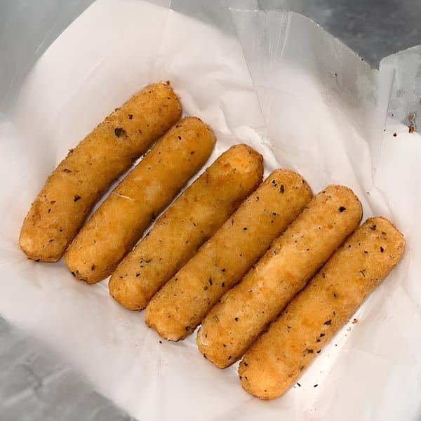 Six golden-brown mozzarella sticks, lightly seasoned, resting in a white paper-lined basket from Harold's 25.